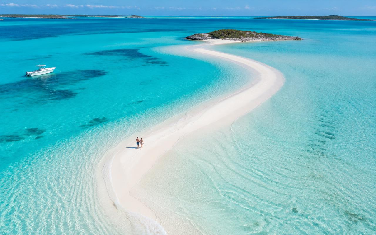 A pale sandbar curving through shallow turquoise water in the Exumas, Bahamas
